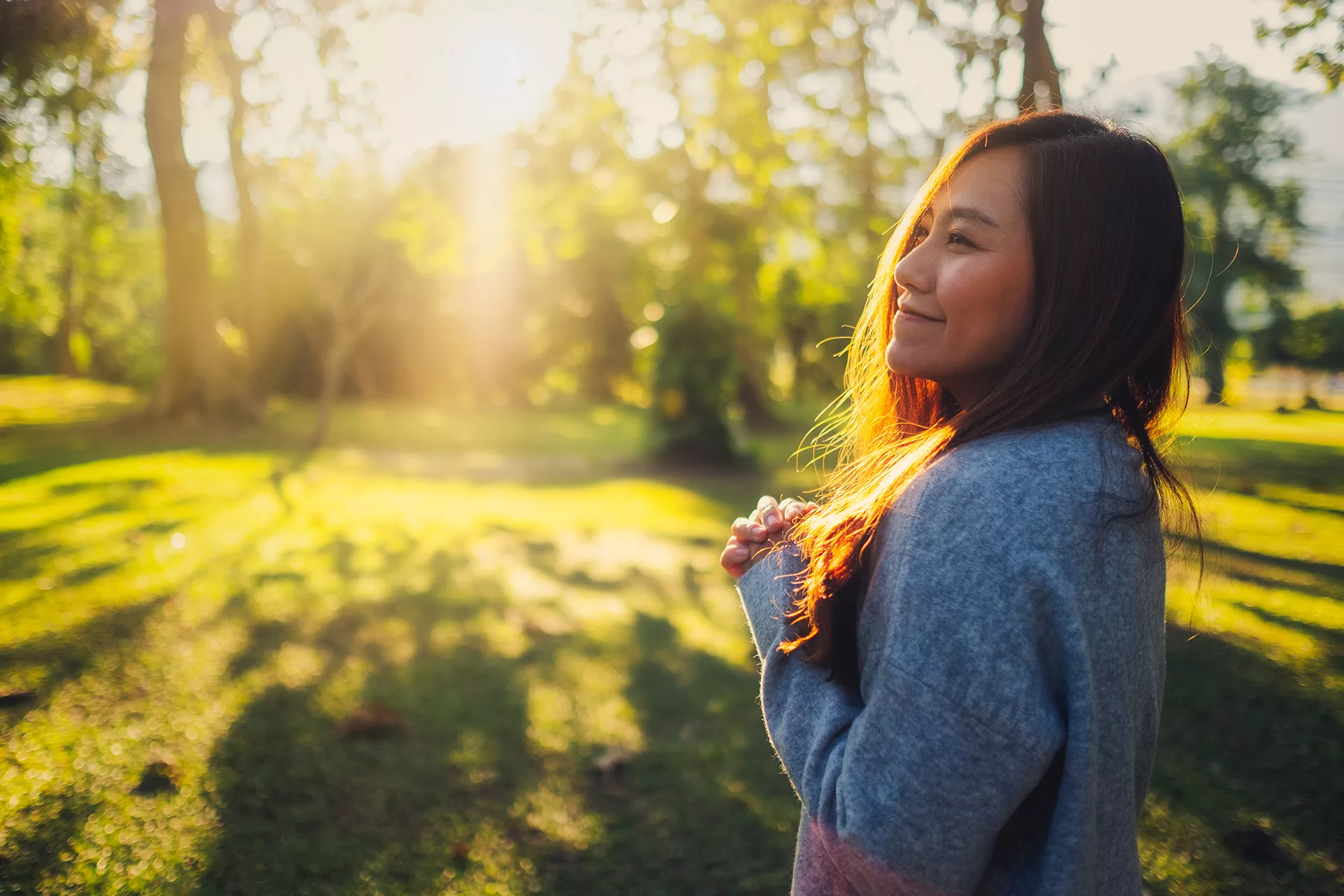 woman smiling with hands clasped outside