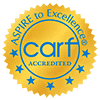 Gold seal with blue text reading "ASPIRE to Excellence," showing the acronym "carf" and the word "ACCREDITED" beneath it, surrounded by a circle of blue stars.